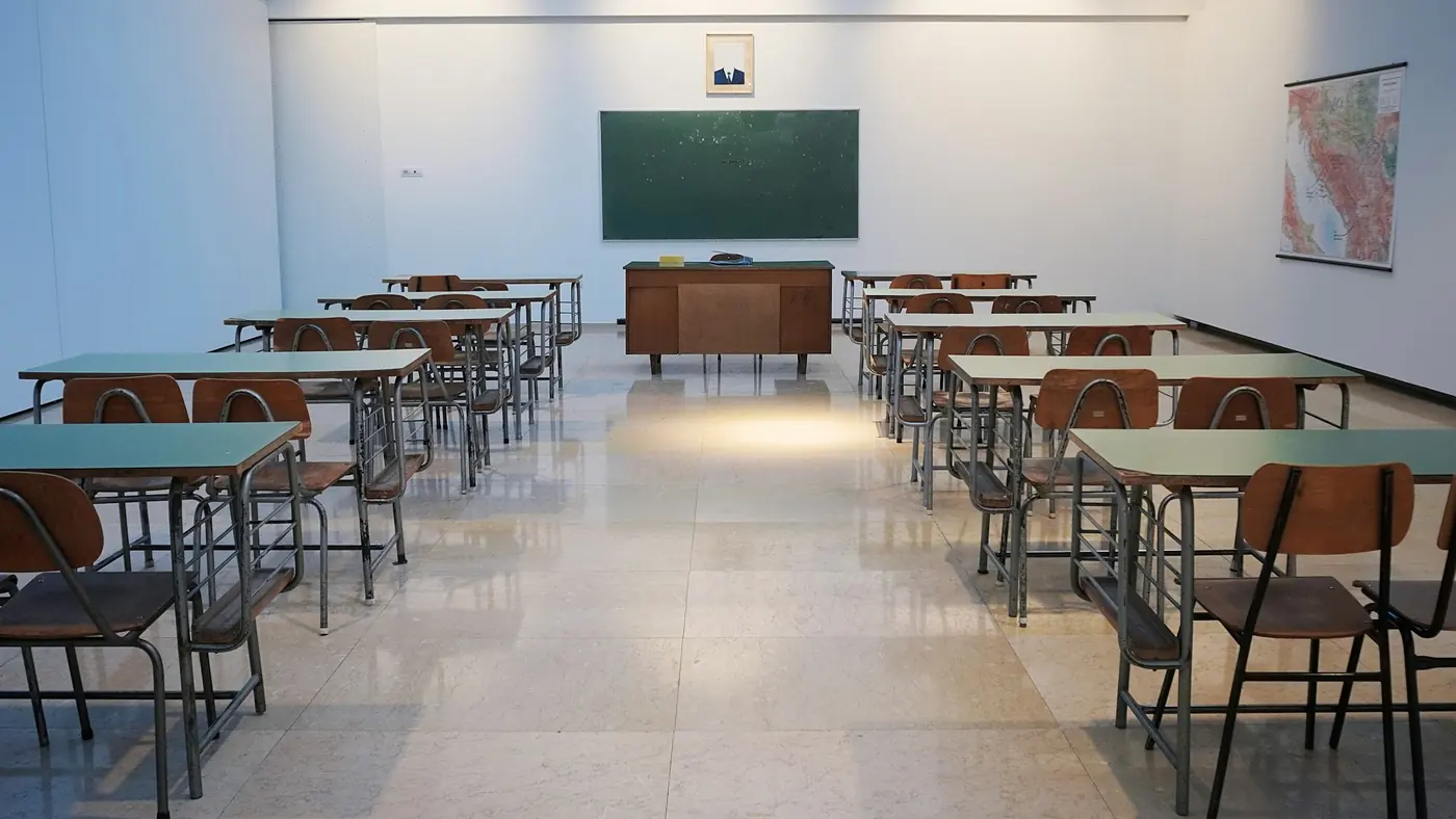 aula vacía con pupitres y pizarra