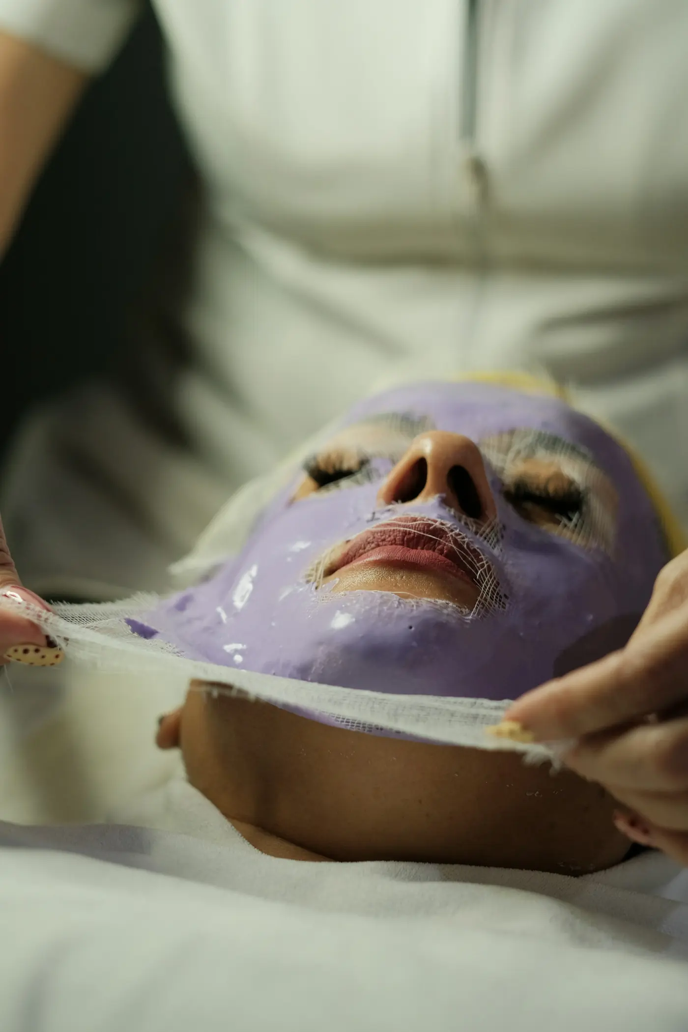 Eliminación de la máscara facial morada de la cara de una mujer