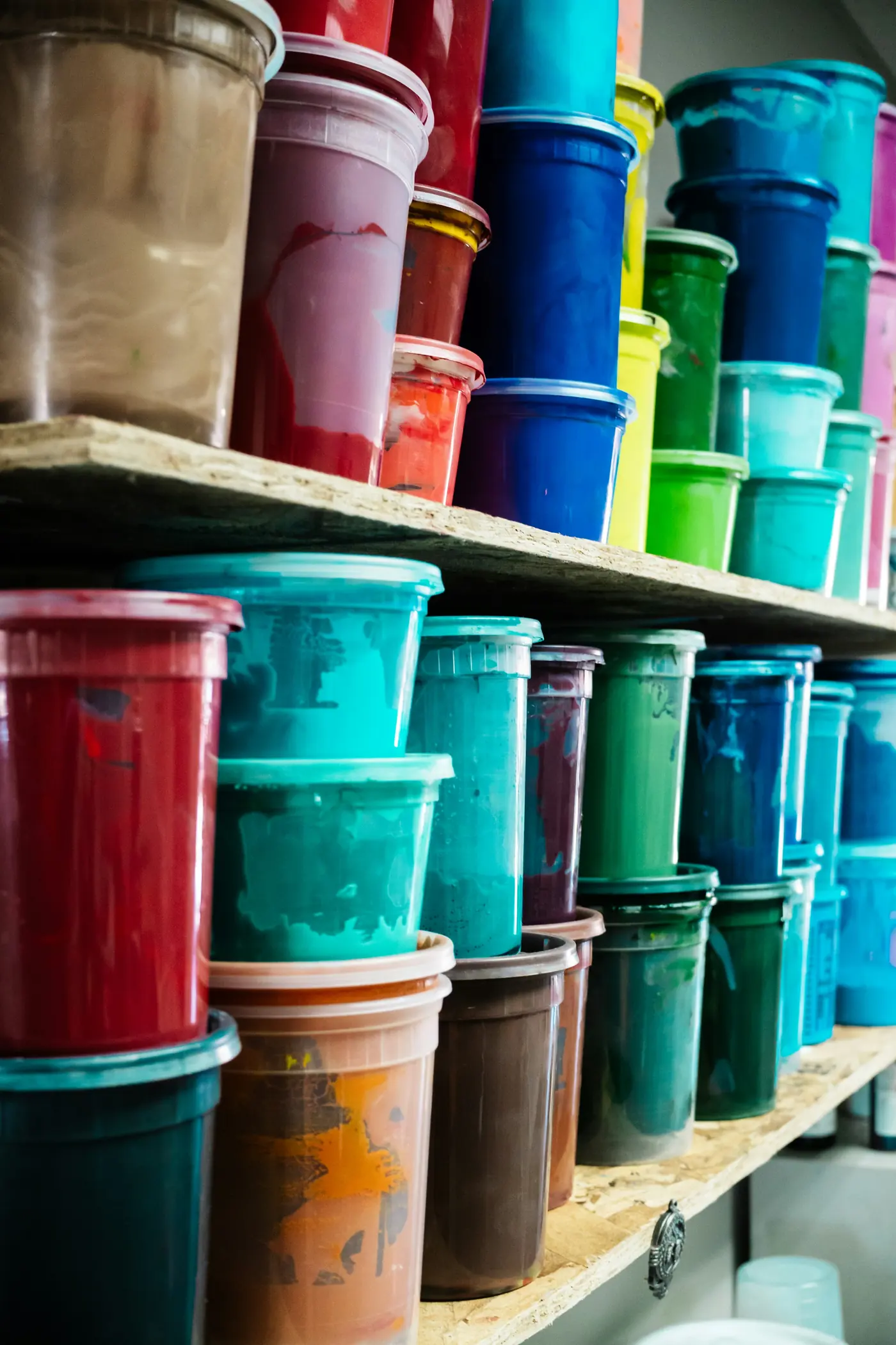 Estanterías llenas de cubos de pintura de colores