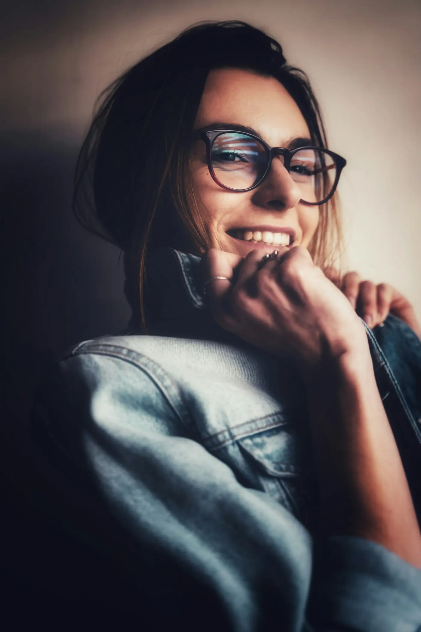 Mujer con gafas de montura negra y chaqueta vaquera azul