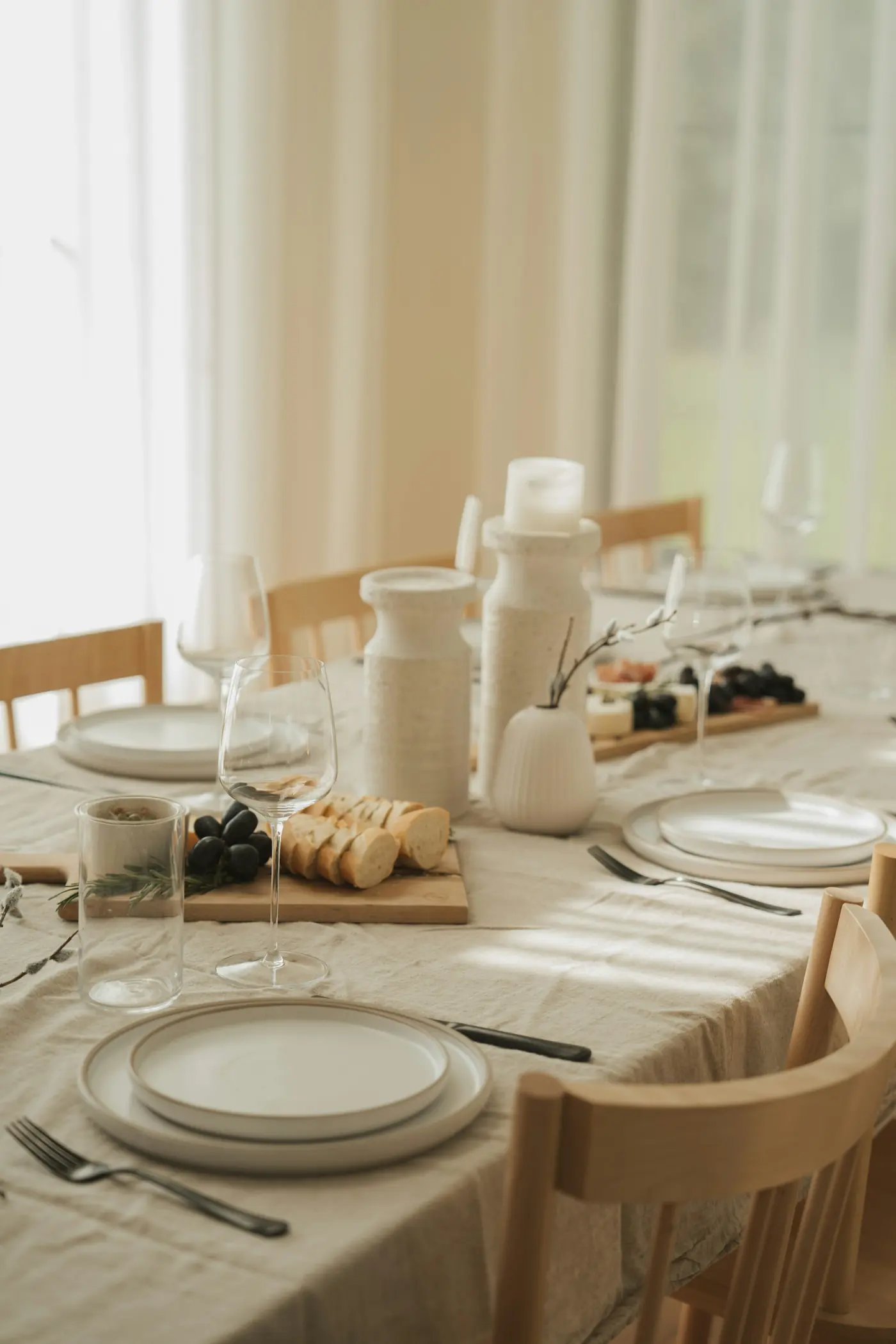 una mesa preparada para una cena formal con copas de vino y platos